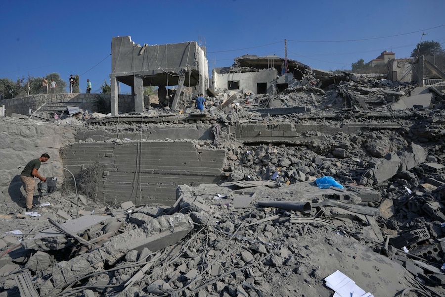 Alcune persone ispezionano un’abitazione distrutta da un attacco aereo israeliano nel villaggio di Ansar, nel Libano meridionale. (AP Photo/Mohammed Zaatari/Associate Press/ LaPresse/APN)