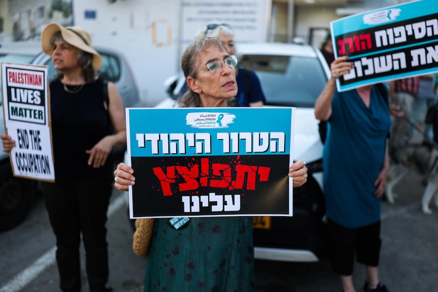 Durante una manifestazione contro l'escalation di violenza dei coloni nei confronti dei palestinesi in Cisgiordania, tenutasi nei pressi della residenza del presidente israeliano a Gerusalemme, alcuni attivisti israeliani espongono cartelli con la scritta in ebraico: «Il terrore ebraico si abbatterà su di noi». (EPA/Atef Safadi)