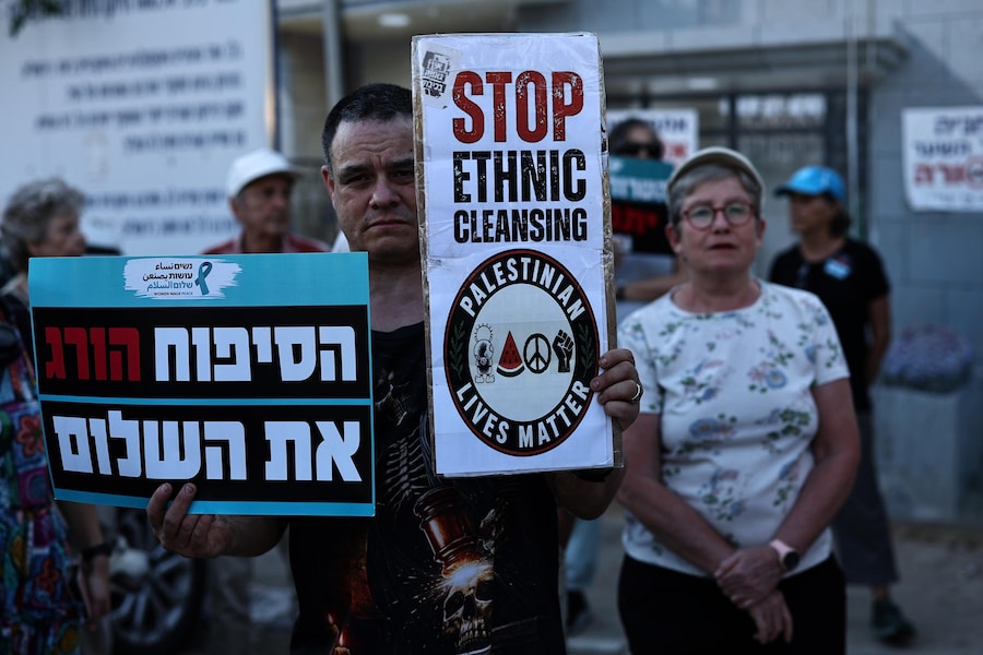 Attivisti israeliani espongono striscioni durante una manifestazione di protesta contro l’escalation di violenza dei coloni nei confronti dei palestinesi in Cisgiordania, nei pressi della residenza del presidente israeliano a Gerusalemme. (EPA/Atef Safadi)