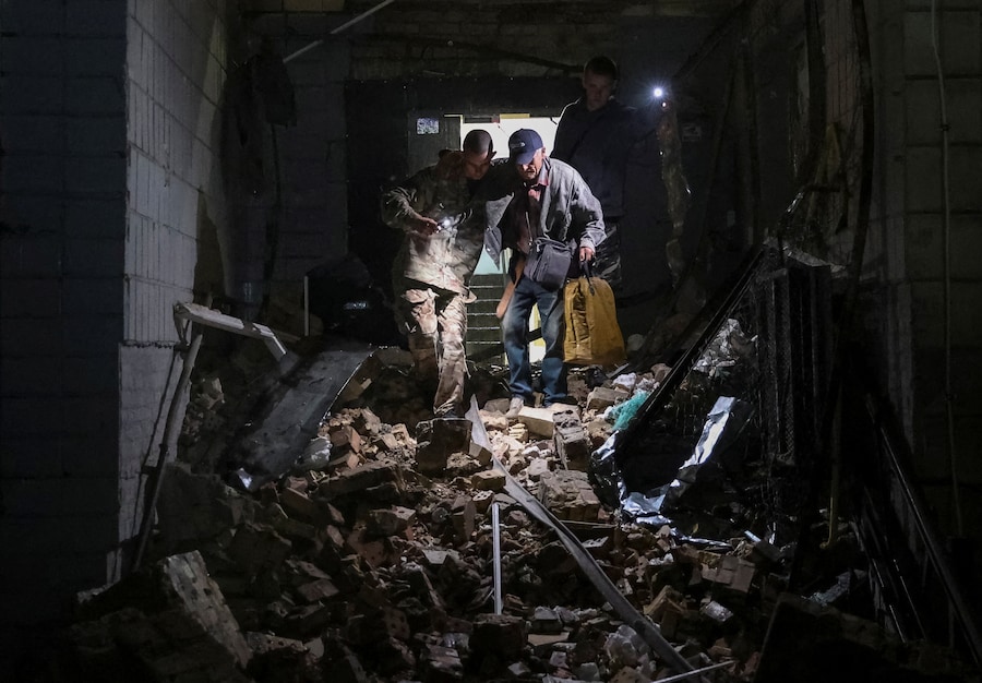 Il 20 agosto 2026 a Kiev, in Ucraina, alcuni volontari evacuano un residente da un condominio colpito da un missile russo. (REUTERS)