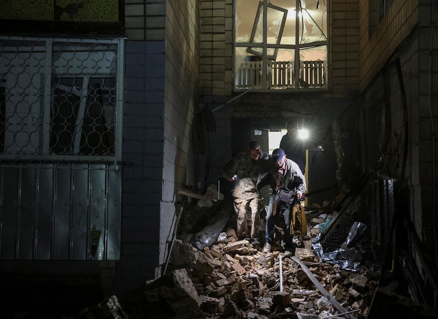 Alcuni volontari evacuano un residente da un condominio colpito da un missile russo. (REUTERS)