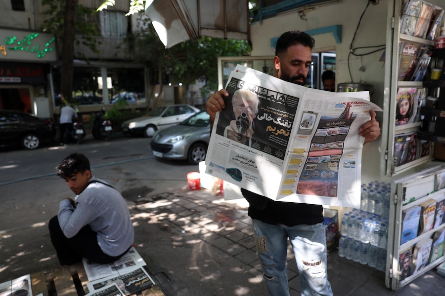 Un uomo iraniano legge una copia del quotidiano iraniano Hamshahri, che riporta una foto del presidente degli Stati Uniti Donald Trump e un titolo in persiano, “La pistola scarica delle sanzioni”, in cui si parla della nuova dura minaccia economica lanciata da Trump contro l’Iran, davanti a un’edicola a Teheran, in Iran (EPA)