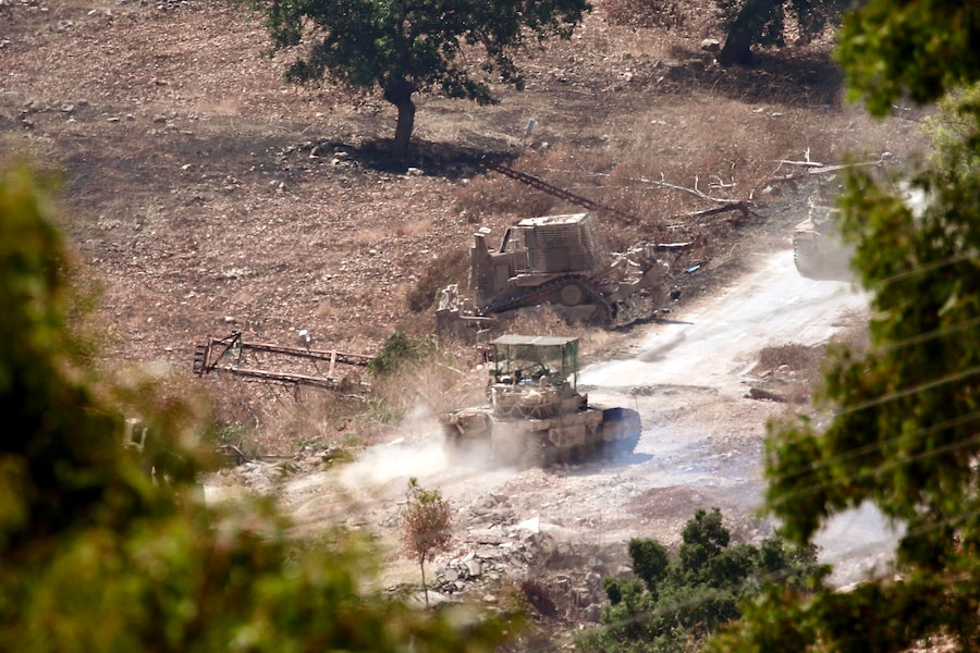 Veicoli blindati israeliani attraversano la zona di Wadi al-Slouki, vista dal villaggio di Chaqra, nel Libano meridionale (EPA)