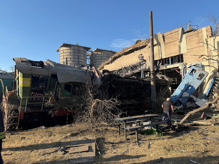 Un dipendente cammina accanto a una locomotiva gravemente danneggiata durante gli attacchi missilistici russi sferrati contro un complesso di un deposito ferroviario a Kiev, Ucraina (via REUTERS)