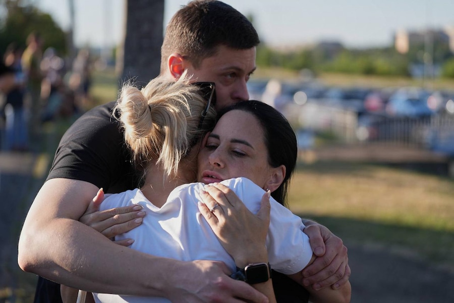 Alcune persone si abbracciano nei pressi di un centro commerciale in fiamme a seguito di un attacco con droni russi a Kryvyi Rih, in Ucraina (APN)
