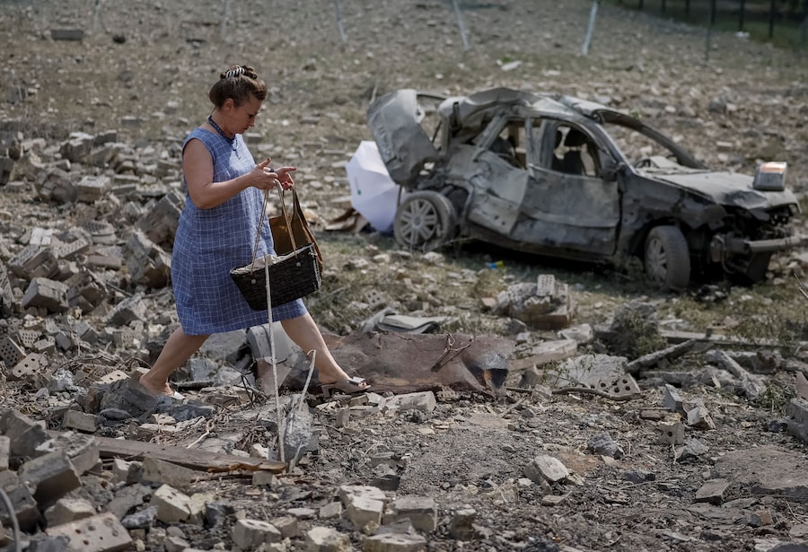 Una donna cammina sul luogo dell'attacco missilistico a Kiev (REUTERS)