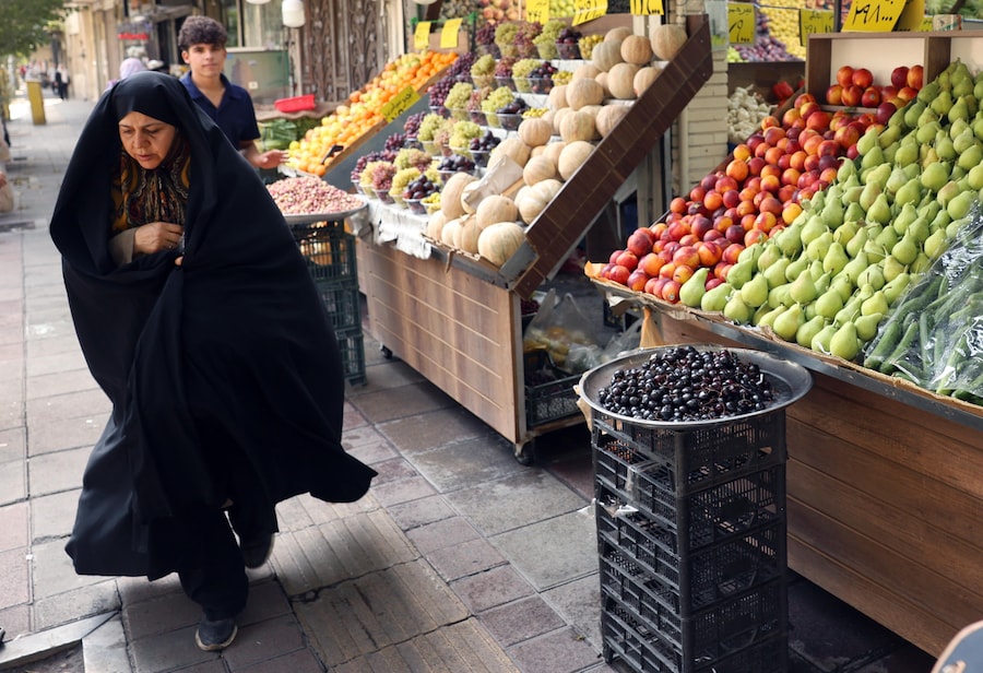 Una donna iraniana con il burqa cammina in un mercato di strada a Teheran, in Iran (EPA)