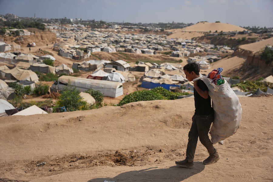 Un ragazzino palestinese esce da una discarica dopo aver raccolto materiali combustibili da utilizzare come combustibile per cucinare a causa della carenza di gas da cucina, a Deir al-Balah, nella Striscia di Gaza centrale (APN)