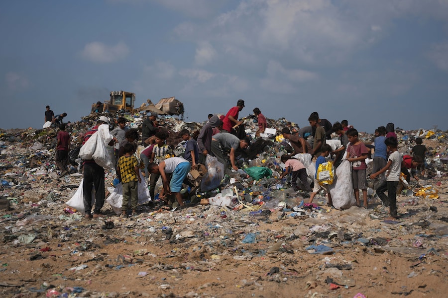 A Deir al-Balah, nella Striscia di Gaza centrale, alcuni palestinesi rovistano in una discarica alla ricerca di materiali combustibili da utilizzare come combustibile per cucinare, a causa della carenza di gas da cucina (APN)
