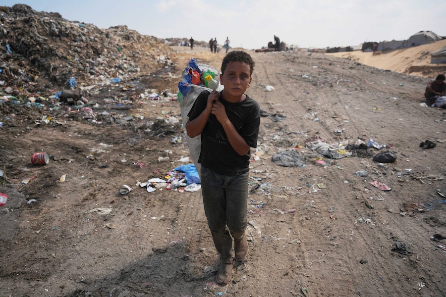 Un ragazzino palestinese si allontana da una discarica dopo aver raccolto materiali combustibili da utilizzare come combustibile per cucinare, a Deir al-Balah, nella Striscia di Gaza centrale (APN)