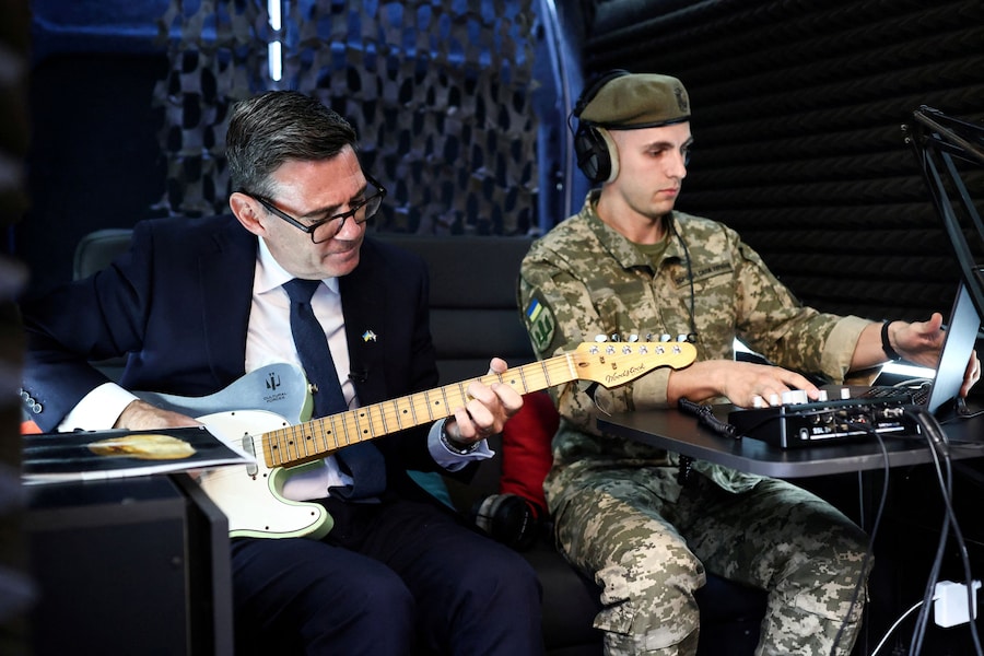 Il primo ministro britannico Andy Burnham suona la chitarra nello studio di registrazione mobile dell’unità militare e artistica “Cultural Forces Frontline”, Kiev, Ucraina, il 24 agosto 2026. (via REUTERS)