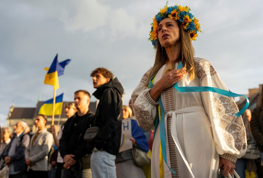 Una donna si porta la mano al cuore durante l'inno nazionale ucraino in occasione di una manifestazione per celebrare la Festa dell'Indipendenza dell'Ucraina in Piazza del Castello, a Varsavia, in Polonia, il 24 agosto 2026. (REUTERS)
