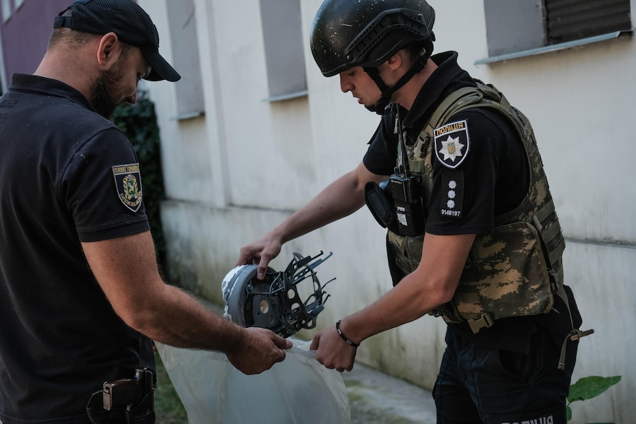 Agenti di polizia ucraini recuperano i rottami di un drone kamikaze russo di tipo Shahed, precipitato in una zona residenziale di Kharkiv, in Ucraina, il 25 agosto 2026. (EPA)