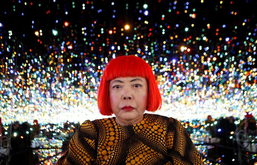 L'artista giapponese Yayoi Kusama posa per una fotografia all'interno della sua installazione "Infinity Mirrored Room", intitolata "The Souls of Millions of Light Years Away", durante un'anteprima per la stampa della sua nuova mostra presso la galleria David Zwirner di New York, negli Stati Uniti, il 7 novembre 2013. (REUTERS/Mike Segar/File Photo)