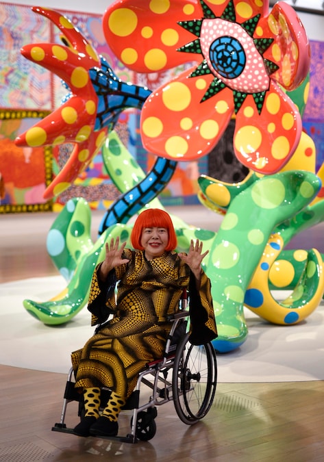 L'artista giapponese Yayoi Kusama posa accanto alle sculture delle sue serie “Fiori che sbocciano a mezzanotte” e “Fiori che sbocciano domani” durante un’anteprima per la stampa della mostra “Yayoi Kusama: My Eternal Soul» presso il Centro Nazionale d’Arte di Tokyo, in Giappone, il 21 febbraio 2017. (EPAEPA/Franck Robichon)
