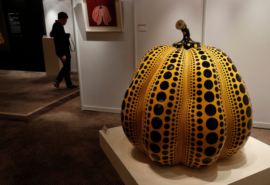 Un uomo passa davanti all'opera "Pumpkin" dell'artista giapponese Yayoi Kusama durante l'anteprima per la stampa dell'asta Ravenel a Hong Kong, venerdì 23 novembre 2012. (AP Photo/Vincent Yu, File/ Associated Press / LaPresse/APN)