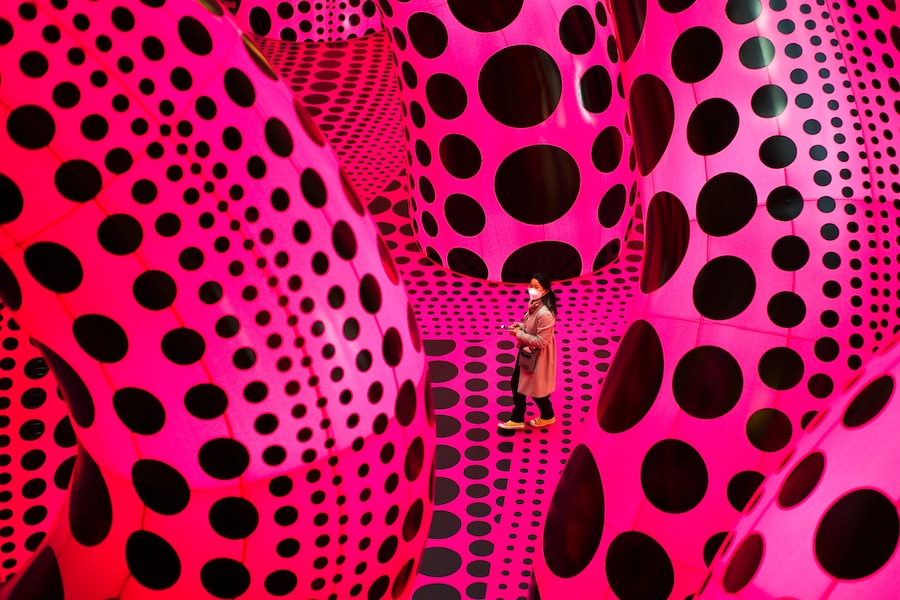 Una donna attraversa l'opera d'arte "A Bouquet of Love I Saw in the Universe" di Yayoi Kusama durante l'anteprima per la stampa di una mostra retrospettiva dedicata all'artista giapponese presso il museo Martin Gropius Bau di Berlino, in Germania, giovedì 22 aprile 2021. Solo Italia e Spagna (AP Photo/Markus Schreiber, Archivio/Associated Press / LaPresse/APN)
