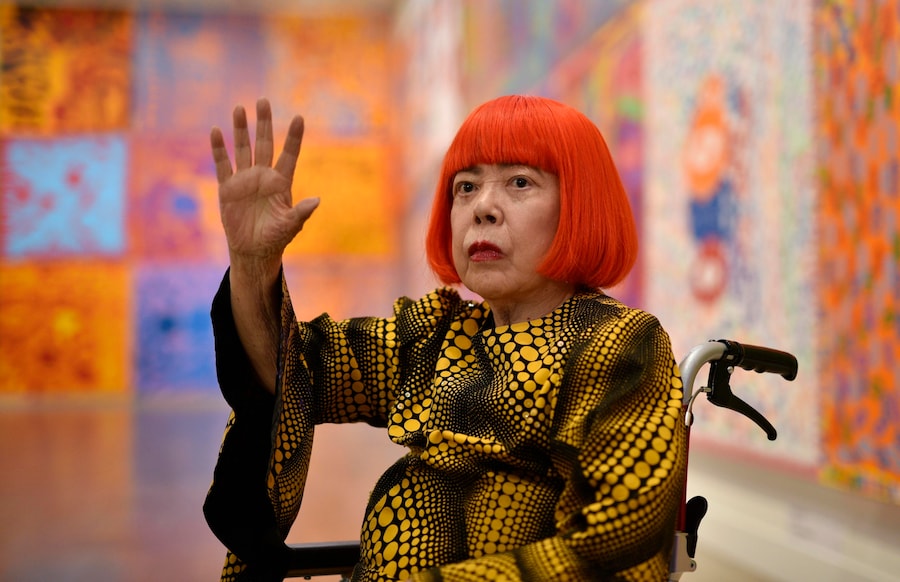 L'artista giapponese Yayoi Kusama posa accanto alle sue opere durante un'anteprima per la stampa della mostra “Yayoi Kusama: My Eternal Soul” presso il Centro Nazionale d'Arte di Tokyo, in Giappone, il 21 febbraio 2017. (EPA/Franck Robichon)
