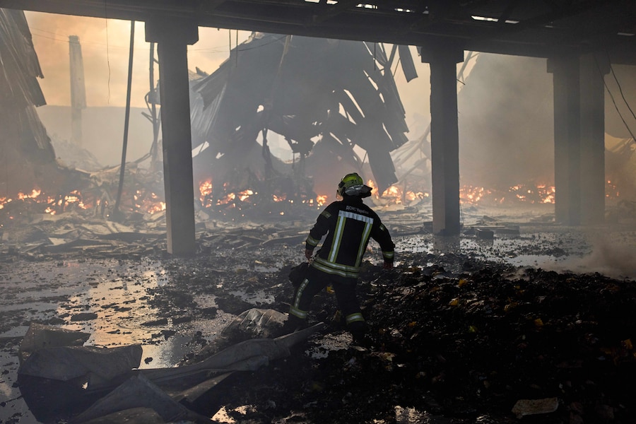 Un vigile del fuoco cerca di spegnere un incendio in un magazzino distrutto a seguito degli attacchi con droni russi alla periferia di Kiev. (Foto AP/Francisco Seco/APNAPN)