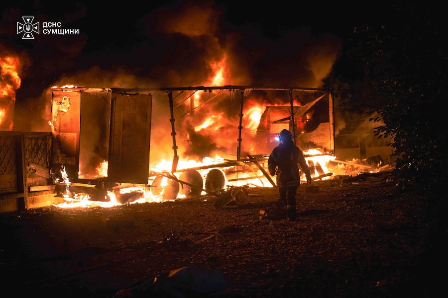 Un vigile del fuoco passa accanto a un autoarticolato in fiamme presso un magazzino colpito da un attacco aereo russo in tarda serata, a Sumy, in Ucraina. (Ufficio stampa del Servizio statale di emergenza dell’Ucraina nella regione di Sumy/Foto fornita tramite REUTERS)