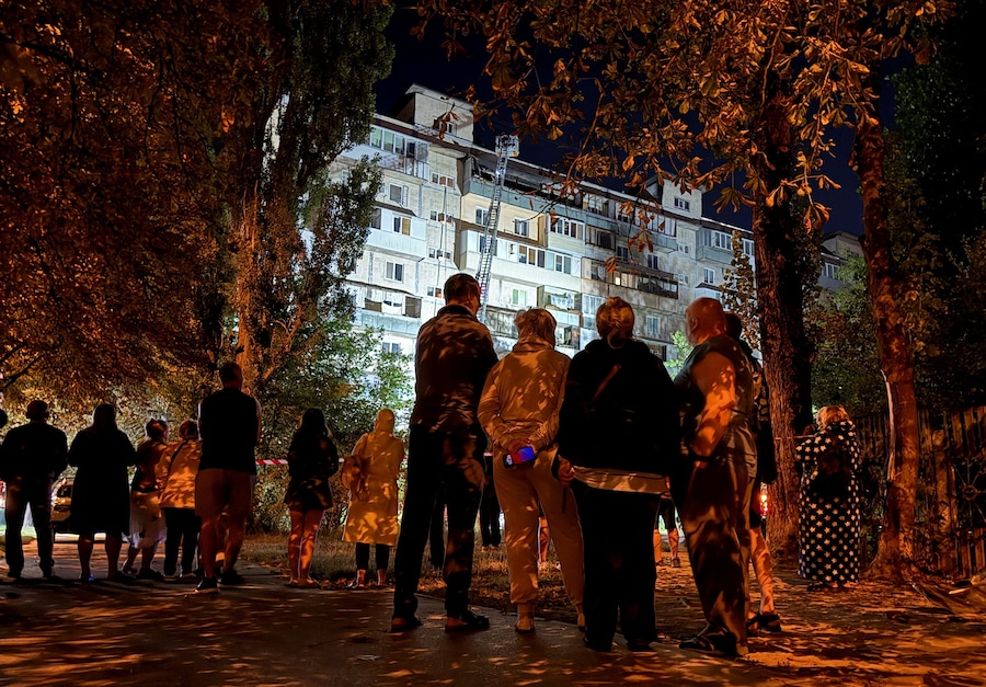 Alcuni residenti si trovano sul luogo di un condominio distrutto da un attacco con droni russi, a Kiev, Ucraina, il 29 agosto 2026. Foto scattata con un cellulare. (REUTERS/Stringer)