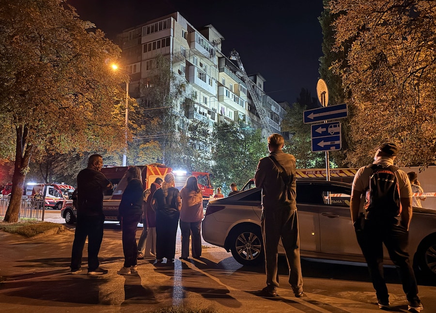 Alcuni residenti si trovano sul luogo di un condominio distrutto da un attacco con droni russi, a Kiev, Ucraina, il 29 agosto 2026. Foto scattata con un cellulare. (REUTERS/Stringer)