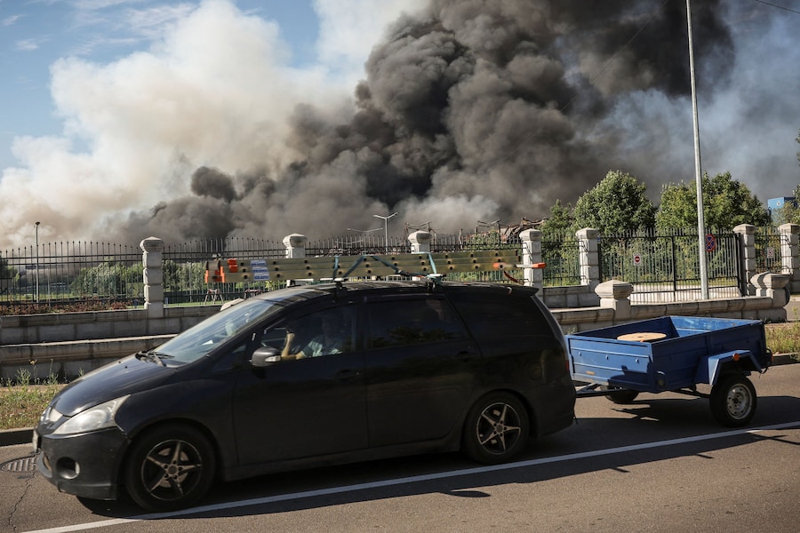 Un'auto passa accanto al luogo in cui si è verificato un attacco con droni russi, mentre si alza il fumo, nella regione di Kiev, Ucraina, il 29 agosto 2026. (REUTERS/Alina Smutko)