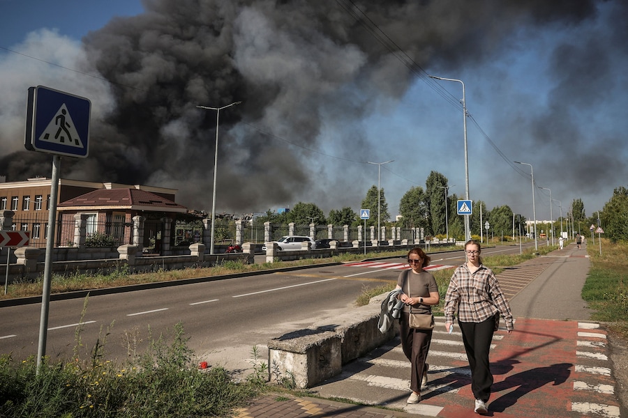 Alcuni residenti passano davanti al luogo colpito da un attacco con droni russi mentre sale il fumo, nella regione di Kiev, Ucraina, il 29 agosto 2026. (REUTERS/Alina Smutko)