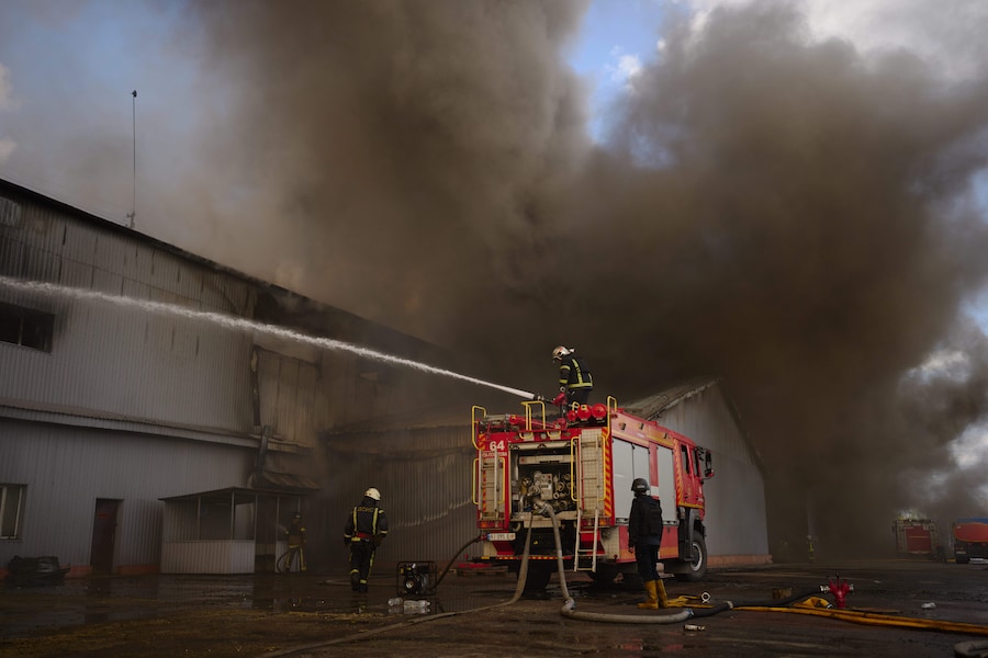 I vigili del fuoco cercano di spegnere un incendio divampato in un magazzino distrutto a seguito degli attacchi con droni russi alla periferia di Kiev. (Foto AP/Francisco Seco/APN)