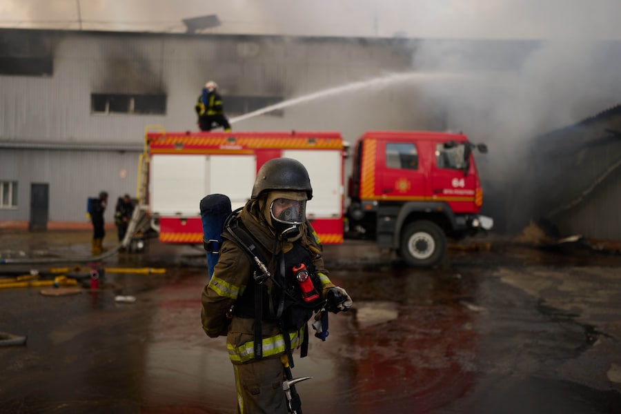 I vigili del fuoco cercano di spegnere un incendio in un magazzino distrutto a seguito degli attacchi con droni russi alla periferia di Kiev. (Foto AP/Francisco Seco/APN)