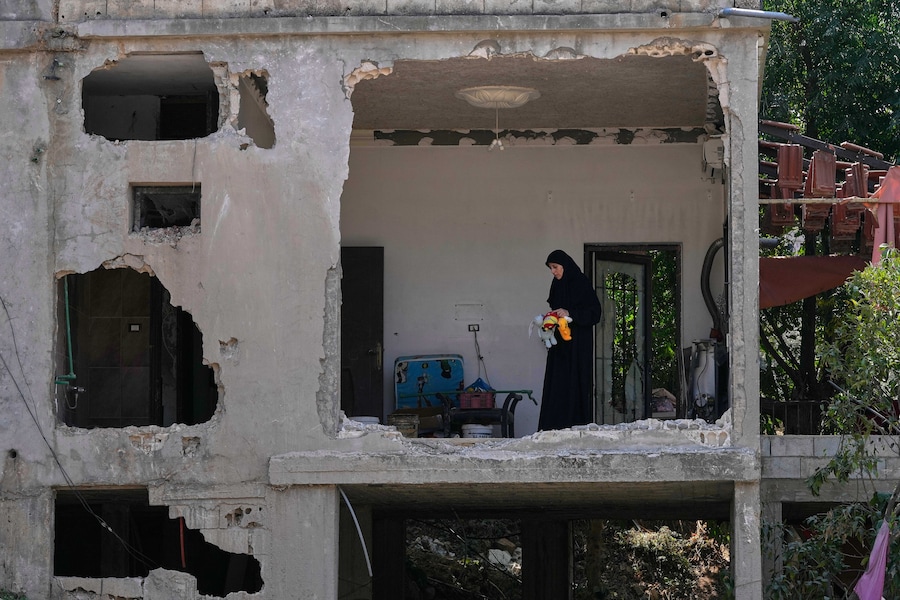 Una donna ispeziona la sua casa danneggiata, colpita da un attacco aereo israeliano nel villaggio di Arab Salim, nel sud del Libano. (Foto AP/Mohammed Zaatari/APN)