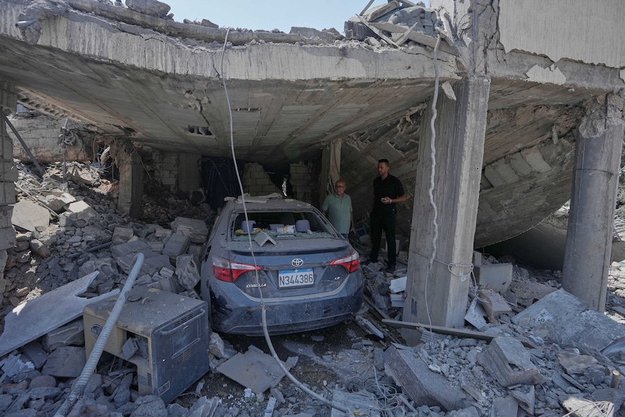 Alcune persone ispezionano una casa distrutta, colpita da un attacco aereo israeliano nel villaggio di Arab Salim, nel Libano meridionale. (Foto AP/Mohammed Zaatari/APN)
