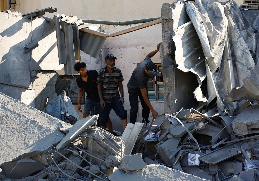 I palestinesi ispezionano una moschea colpita lunedì da un attacco israeliano, sferrato dopo che l’esercito israeliano aveva intimato ai residenti di evacuare la zona, a Deir al-Balah, nella Striscia di Gaza centrale. (REUTERS/Mahmoud Issa)