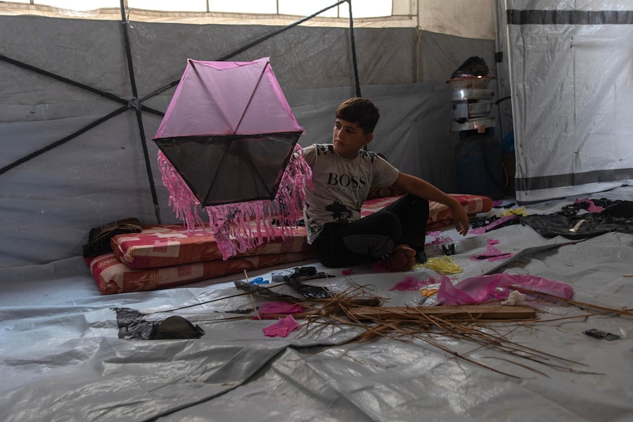 Un bambino palestinese costruisce un aquilone nel campo di al-Mawasi, vicino a Khan Younis, nella parte meridionale della Striscia di Gaza. In mancanza di luoghi sicuri dove giocare, i bambini palestinesi sfollati realizzano aquiloni con materiali di base per affrontare lo sfollamento e il caldo all’interno delle loro tende, e trovare un momento di sollievo. Tuttavia, i recenti avvertimenti dell’esercito israeliano contro il volo degli aquiloni hanno trasformato un innocuo gioco infantile in un’ulteriore fonte di paura e ansia all’interno dei campi profughi. (EPA/Haitham Imad)