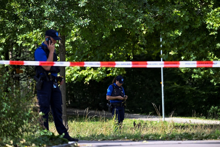Agenti di polizia in piedi accanto al nastro di delimitazione nei pressi del luogo in cui, secondo quanto riferito dalla polizia, si è verificata una sparatoria mortale durante un rave a Schachen, ad Aarau, in Svizzera, il 30 agosto 2026. (REUTERS/Romina Amato)