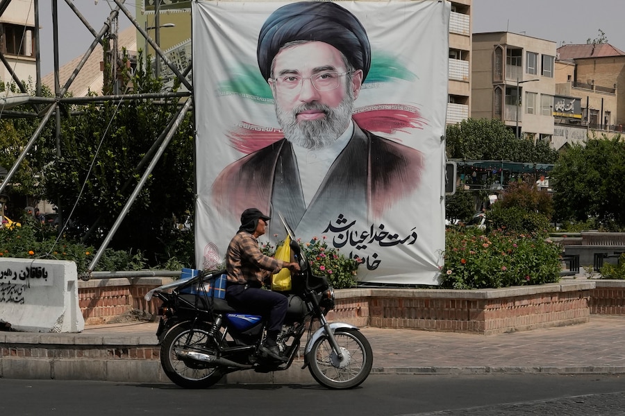 Un uomo passa in auto davanti a uno striscione che raffigura il ritratto della Guida Suprema iraniana, l’Ayatollah Mojtaba Khamenei, nel centro di Teheran, in Iran. (APN)