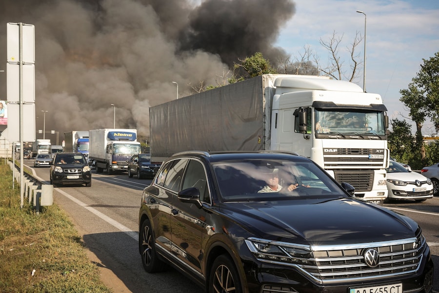 Alcuni veicoli circolano su un'autostrada parzialmente bloccata nei pressi di un magazzino colpito da un attacco con droni russi, nel contesto dell'offensiva russa contro l'Ucraina, nella regione di Kiev. (REUTERS)