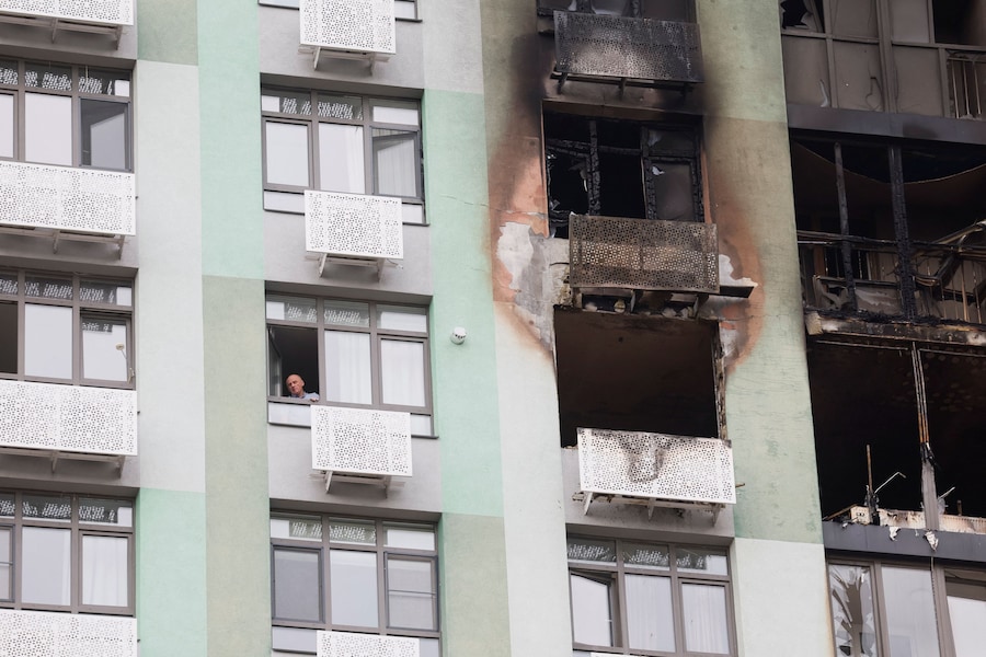 Un uomo guarda fuori dalla finestra di un condominio danneggiato da un attacco con droni russi, nel contesto dell'offensiva russa contro l'Ucraina, a Kiev. (REUTERS)