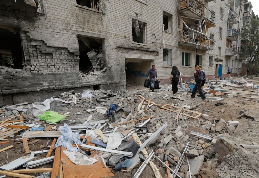 Gli abitanti recuperano i propri effetti personali dagli appartamenti danneggiati sul luogo di un attacco missilistico russo contro una zona residenziale nella città di Boryspil, vicino a Kiev. (EPA)