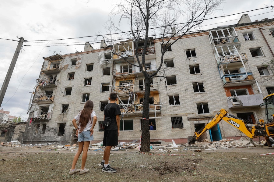 La popolazione locale reagisce sul luogo di un attacco missilistico russo contro una zona residenziale nella città di Boryspil, vicino a Kiev. (EPA)