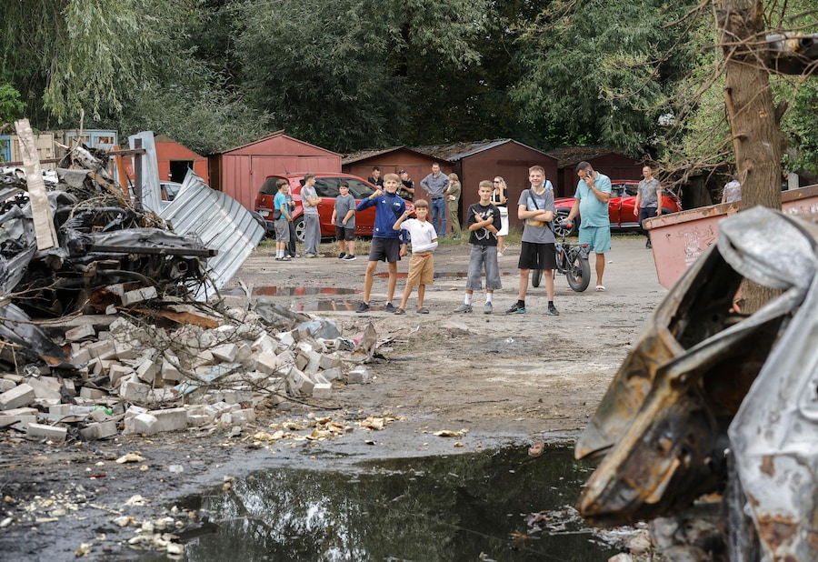 La popolazione locale reagisce sul luogo di un attacco missilistico russo contro una zona residenziale nella città di Boryspil, vicino a Kiev. (EPA)