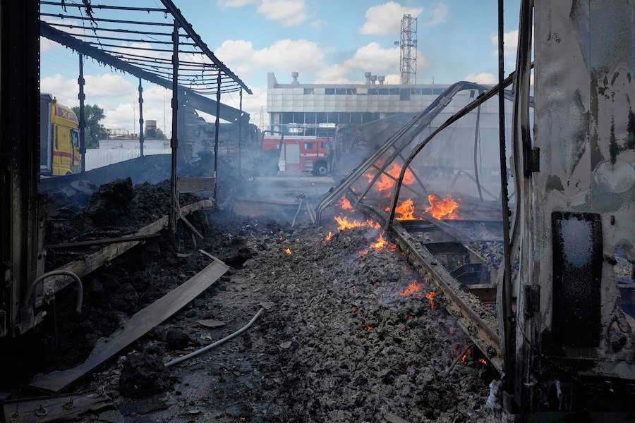 Veicoli in fiamme davanti a dei magazzini in seguito a un attacco aereo russo a Kiev (APN)