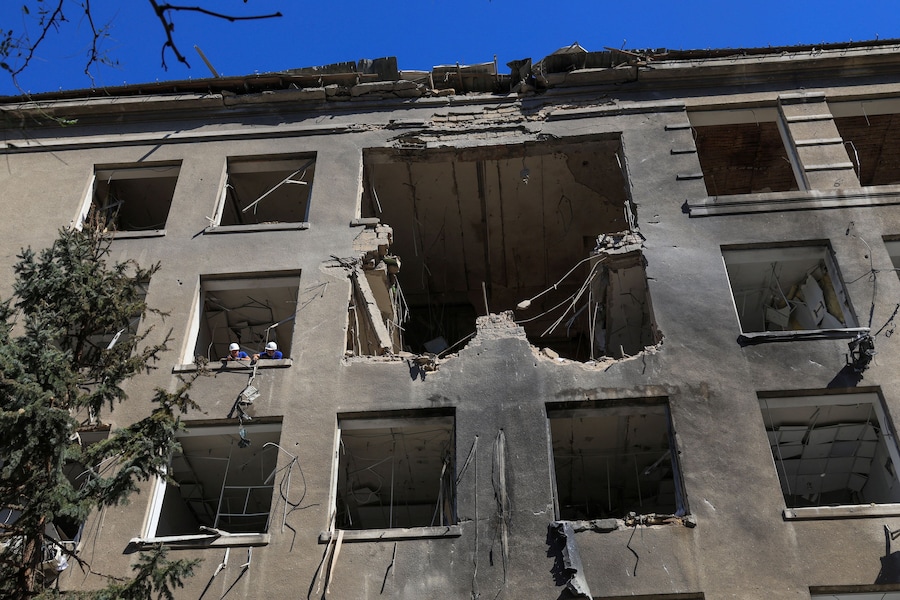 A Odessa alcuni operai rimuovono un condizionatore danneggiato da un edificio di un centro commerciale colpito da un attacco con droni russi (REUTERS)