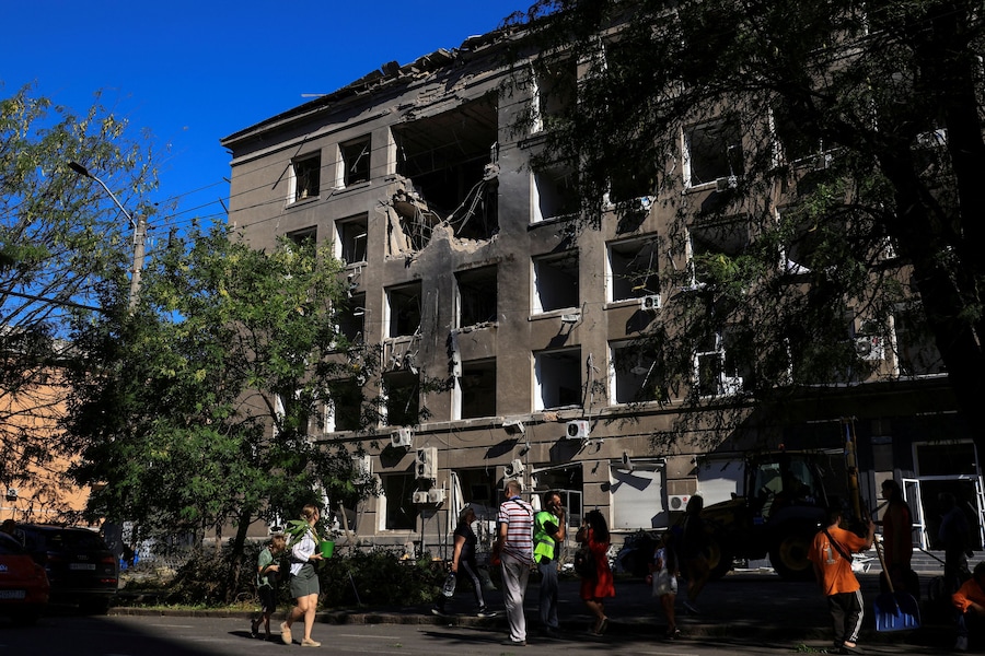 Alcuni residenti camminano davanti a un edificio di un centro commerciale colpito da un attacco con droni russi a Odessa, Ucraina (REUTERS)