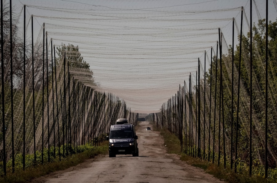 I volontari dell’organizzazione ucraina per il salvataggio degli animali UAnimals guidano un furgone su una strada ricoperta di reti anti-drone mentre aiutano Anatolii Zubko, 53 anni, e sua moglie a evacuare dal loro villaggio natale di Hroza, nel pieno dell’attacco russo all’Ucraina, nella regione di Kharkiv, Ucraina (REUTERS)