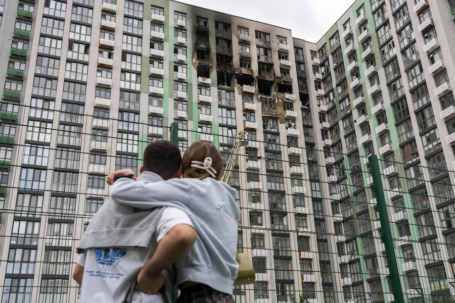 La gente sul luogo di un attacco con droni russi contro un grattacielo residenziale a Kiev, in Ucraina (EPA)