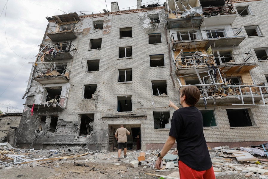 La popolazione locale sul luogo di un attacco missilistico russo contro una zona residenziale nella città di Boryspil, vicino a Kiev, in Ucraina (EPA)