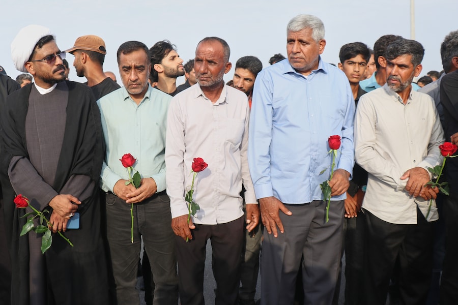 Alcuni uomini, con in mano rose rosse, partecipano a un corteo funebre collettivo in memoria delle vittime di quello che, secondo i media iraniani e un’organizzazione per i diritti umani, sarebbe stato un attacco missilistico statunitense contro un’abitazione in cui si stava celebrando un matrimonio a Kuhestak, nel sud dell’Iran. (APN)