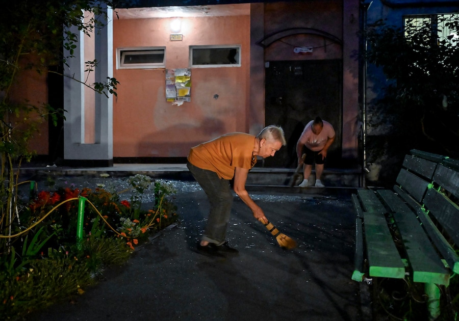 La popolazione locale ripulisce le macerie sul luogo di un attacco con droni russi contro un edificio residenziale di nove piani a Kiev. (EPA)