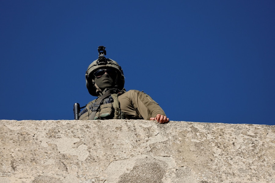 Un soldato israeliano monta la guardia durante la visita settimanale dei coloni israeliani a Hebron, nella Cisgiordania occupata da Israele (REUTERS)